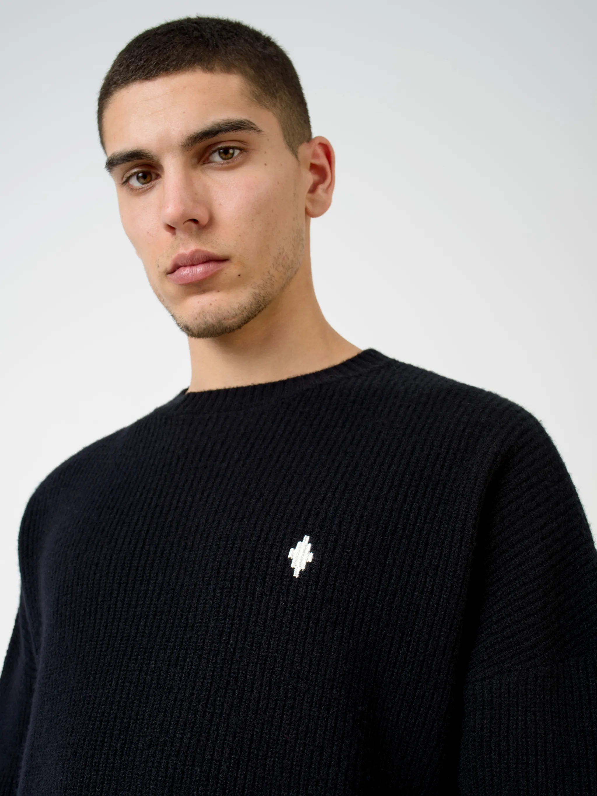 Black wool MBCM ribbed-knit wool jumper from Marcelo Burlon County of Milan featuring chunky ribbed knit, embroidered logo at the chest, embroidered logo to the rear, ribbed edge, crew neck, long sleeves and straight hem.
