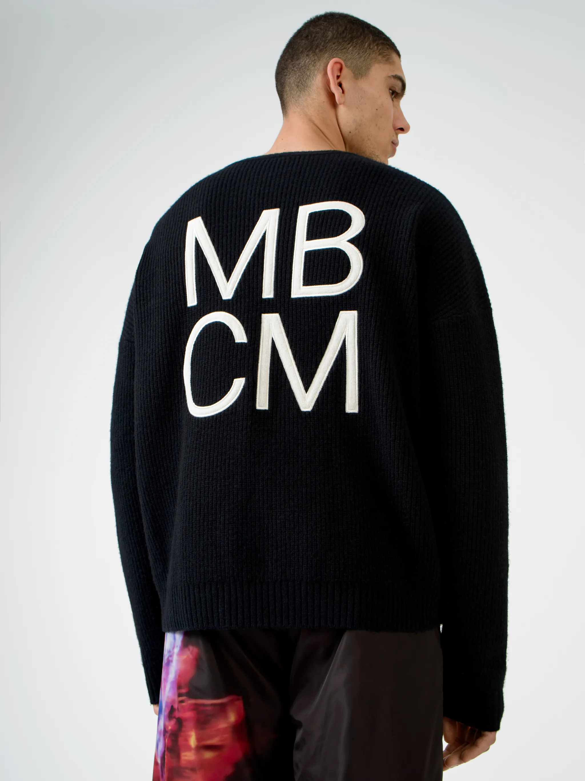 Black wool MBCM ribbed-knit wool jumper from Marcelo Burlon County of Milan featuring chunky ribbed knit, embroidered logo at the chest, embroidered logo to the rear, ribbed edge, crew neck, long sleeves and straight hem.