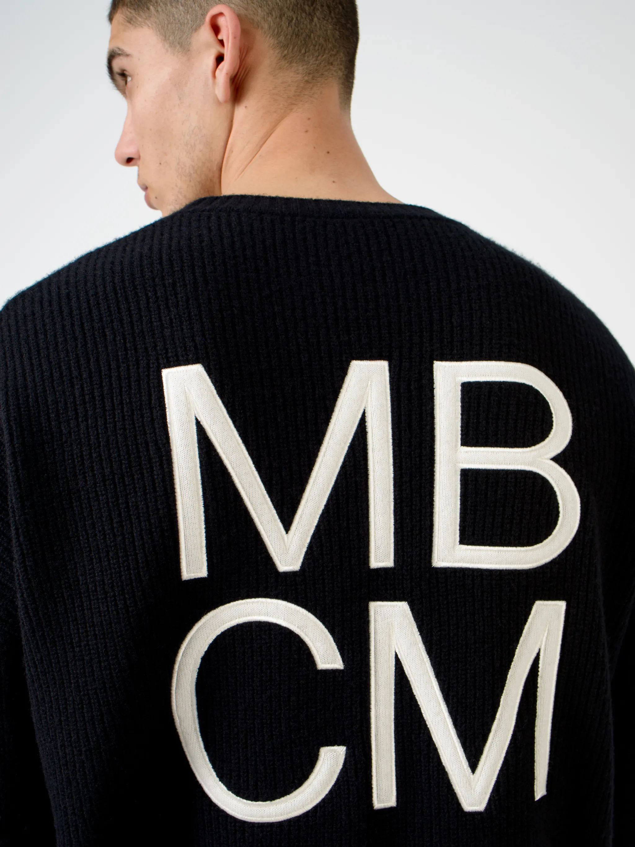 Black wool MBCM ribbed-knit wool jumper from Marcelo Burlon County of Milan featuring chunky ribbed knit, embroidered logo at the chest, embroidered logo to the rear, ribbed edge, crew neck, long sleeves and straight hem.