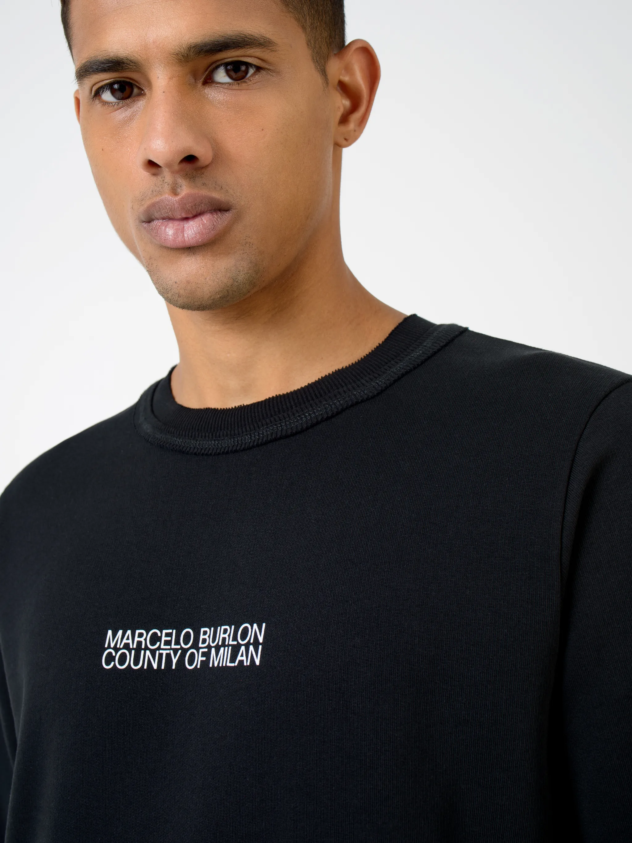 Black cotton Multi Faces crew-neck sweatshirt from Marcelo Burlon County of Milan featuring logo print at the chest, graphic print to the rear, crew neck, long raglan sleeves and straight hem.