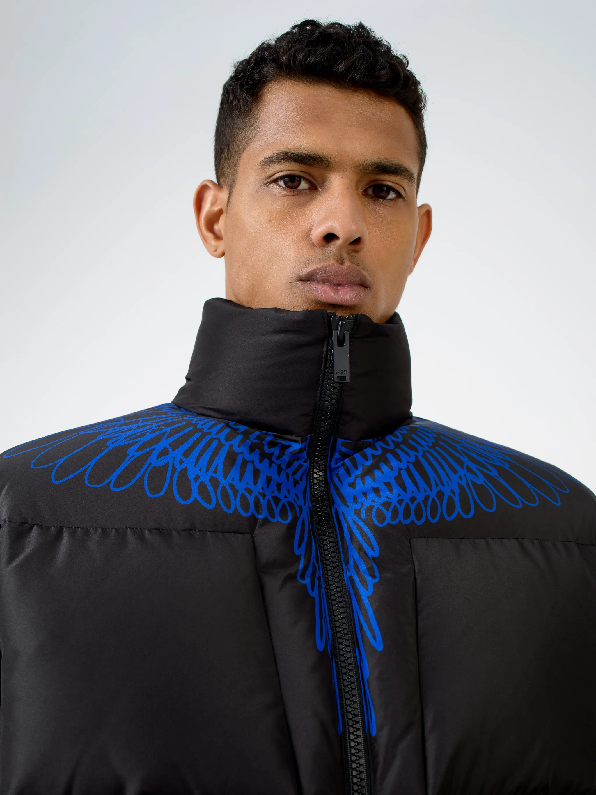 Black/blue wings-detail padded coat from MARCELO BURLON COUNTY OF MILAN featuring stand-up collar, long sleeves, front zip fastening, Wings print and padded.