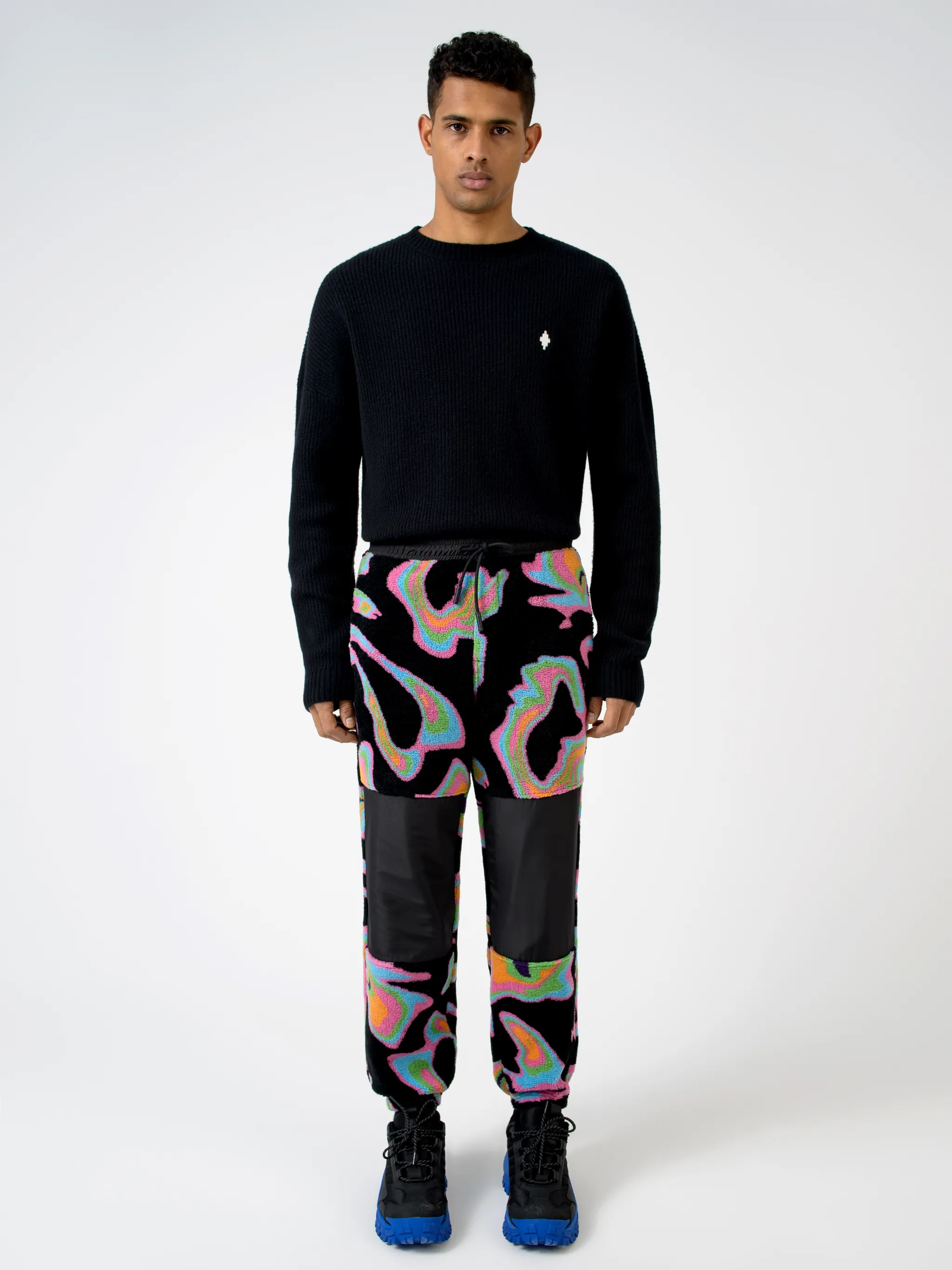 Black/multicolour intarsia Psych pattern track pants from Marcelo Burlon County of Milan featuring patterned intarsia knit, elasticated waistband, drawstring fastening, two side patch pockets, contrasting panel detail and elasticated ankles.