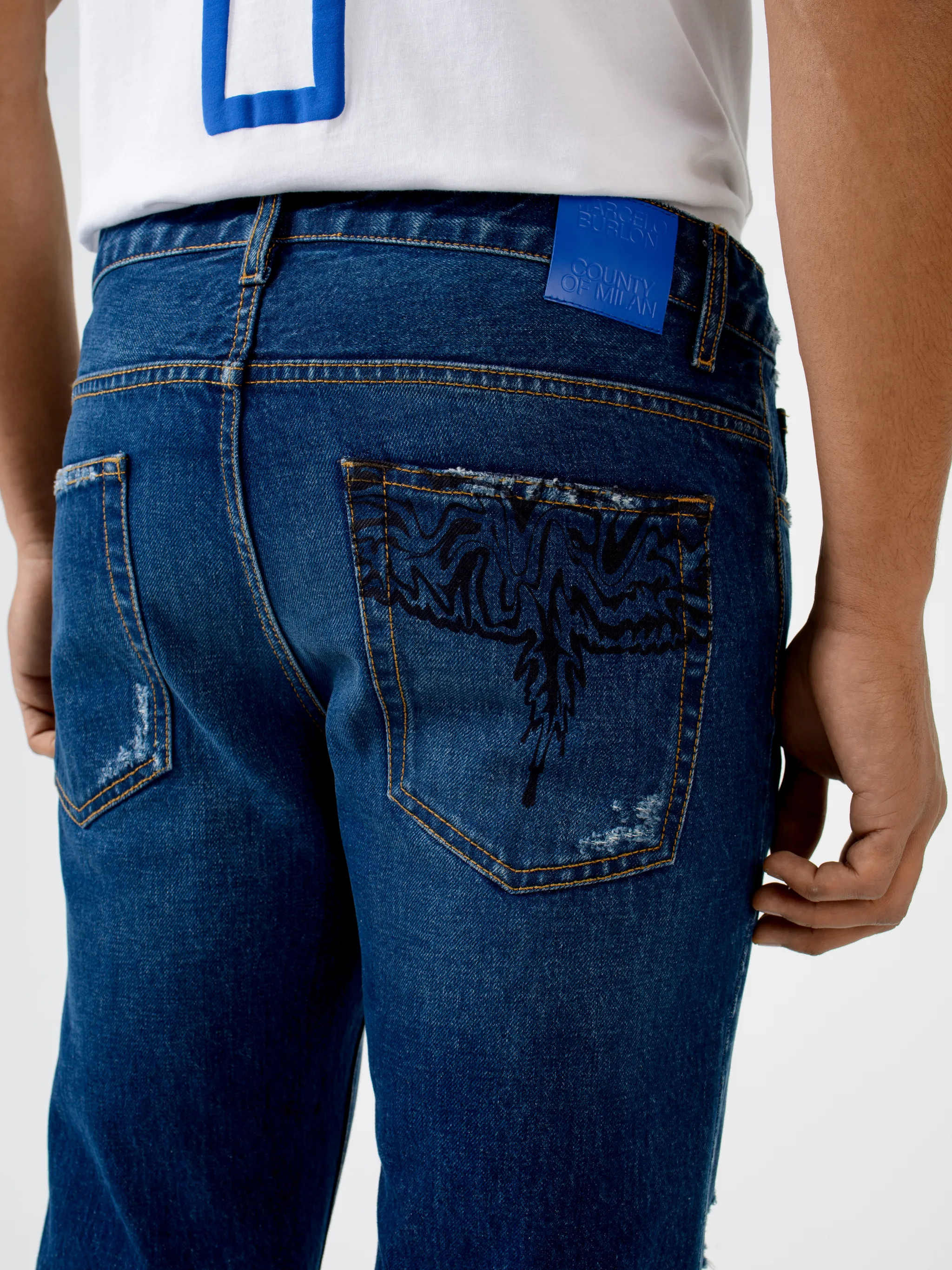 Indigo-blue cotton Wings ripped-detailing slim-fit jeans from Marcelo Burlon County of Milan featuring wings print, logo patch to the rear, ripped detailing, belt loops, mid-rise, front button and zip fastening, slim cut and classic five pockets.
