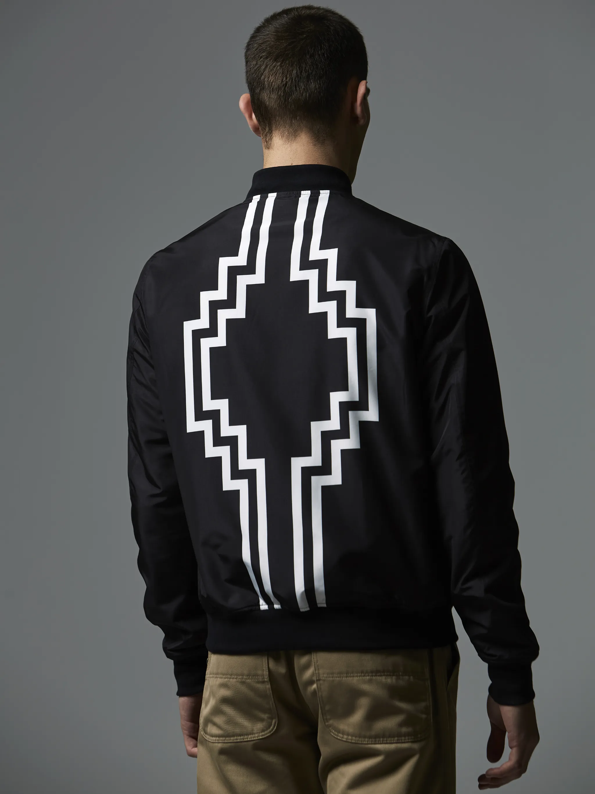Black cotton-blend embroidered logo bomber jacket from Marcelo Burlon County of Milan featuring embroidered logo at the chest, logo print to the rear, front zip fastening, long sleeves and elasticated hem.