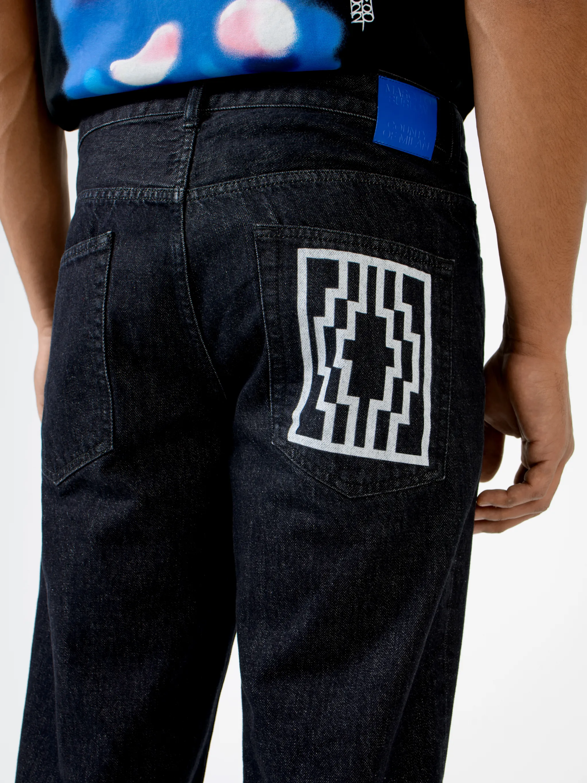 Black cotton Rural Cross slim-fit jeans from Marcelo Burlon County of Milan featuring logo patch to the rear, belt loops, mid-rise, front button and zip fastening, slim cut, classic five pockets and cross print.
