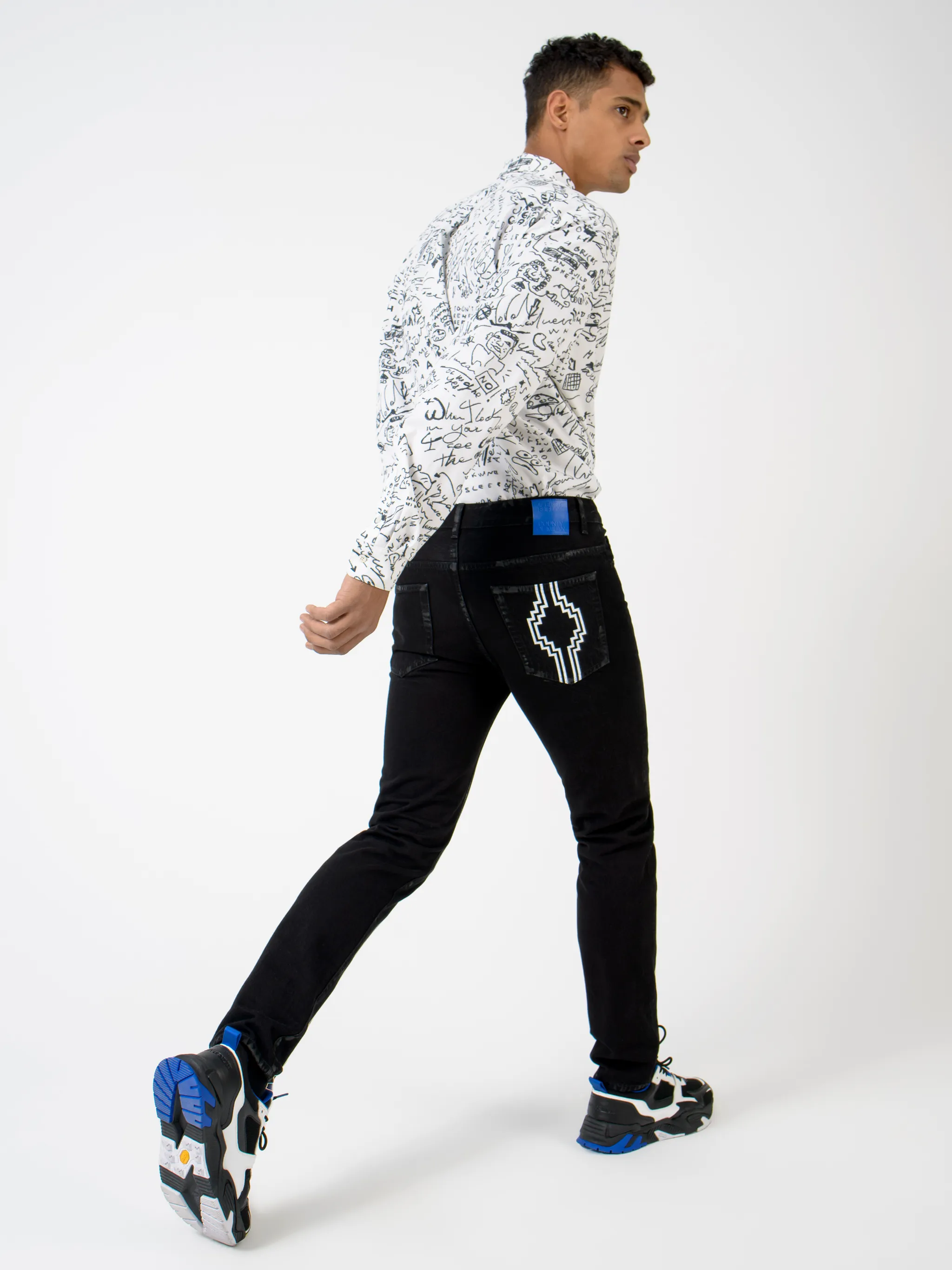 Black cotton-blend Rural Cross slim-fit jeans from Marcelo Burlon County of Milan featuring logo print embellishment, slim cut, belt loops, front button fastening and classic five pockets.