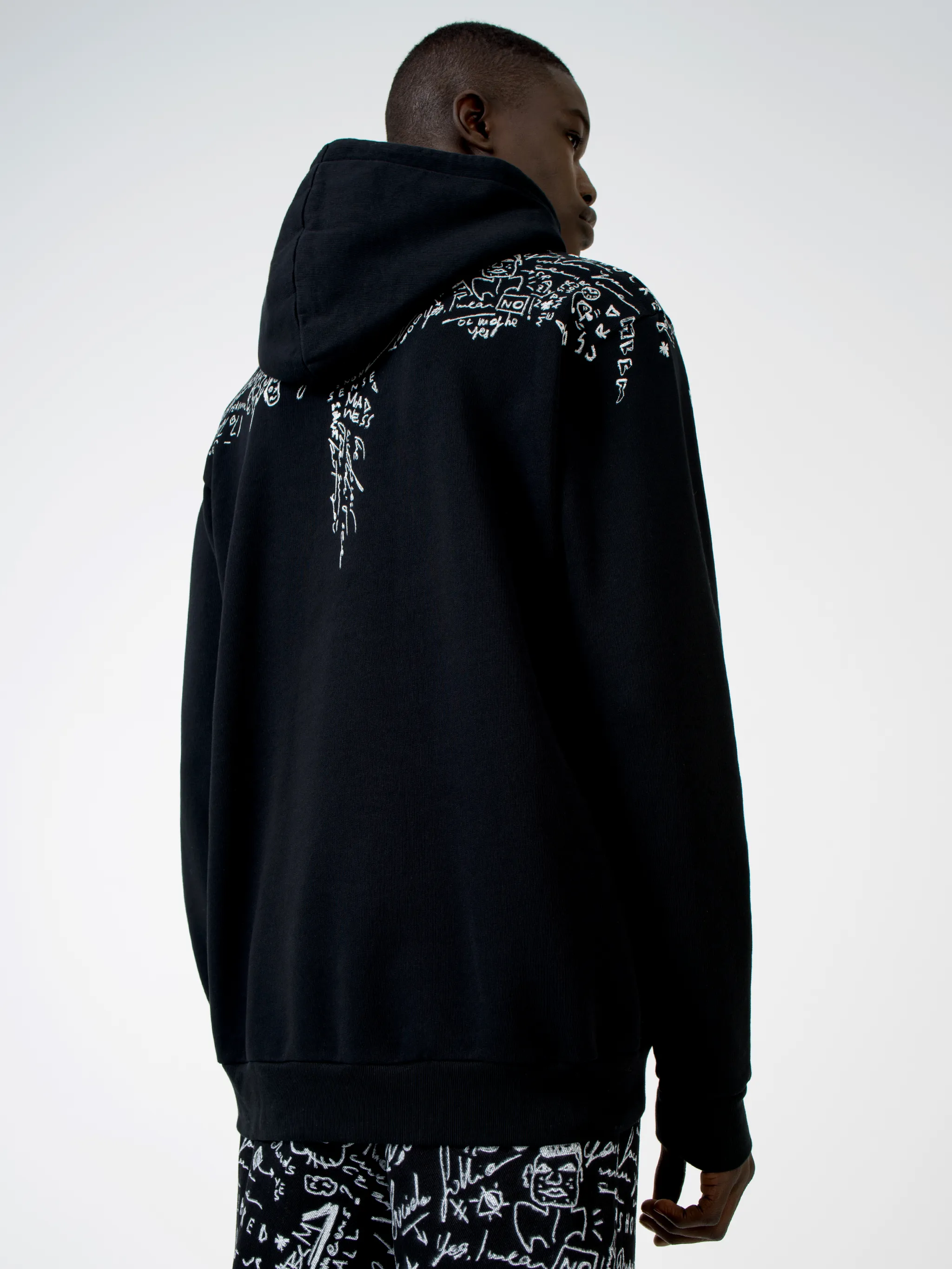 Level up on your casualwear with this black cotton hoodie from Marcelo Burlon County of Milan, printed with doodle logo prints across the chest and shoulders. Get the sketchpad out. Featuring a drawstring hood, a graphic print, long sleeves and a kangaroo pocket.