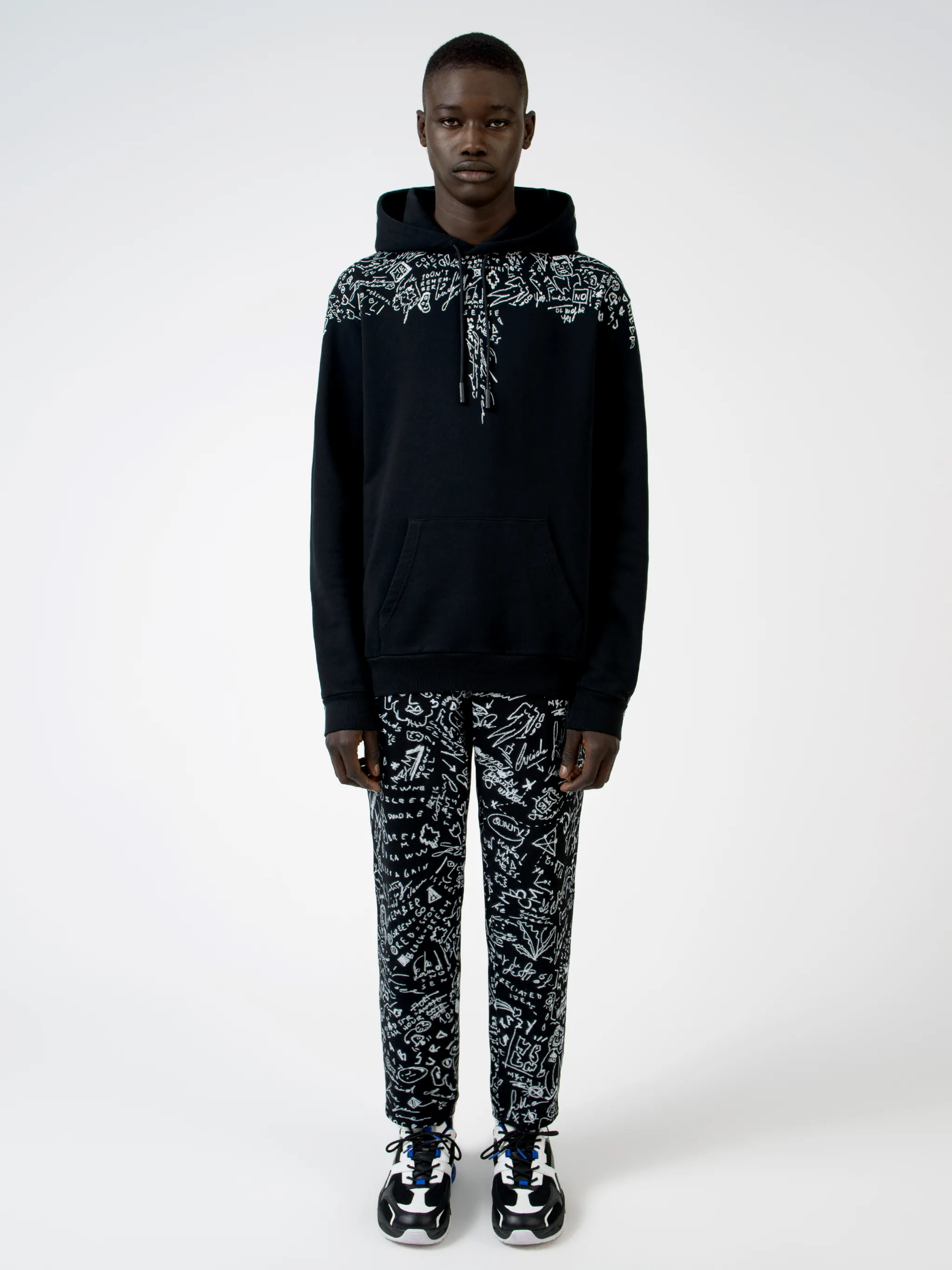 Level up on your casualwear with this black cotton hoodie from Marcelo Burlon County of Milan, printed with doodle logo prints across the chest and shoulders. Get the sketchpad out. Featuring a drawstring hood, a graphic print, long sleeves and a kangaroo pocket.