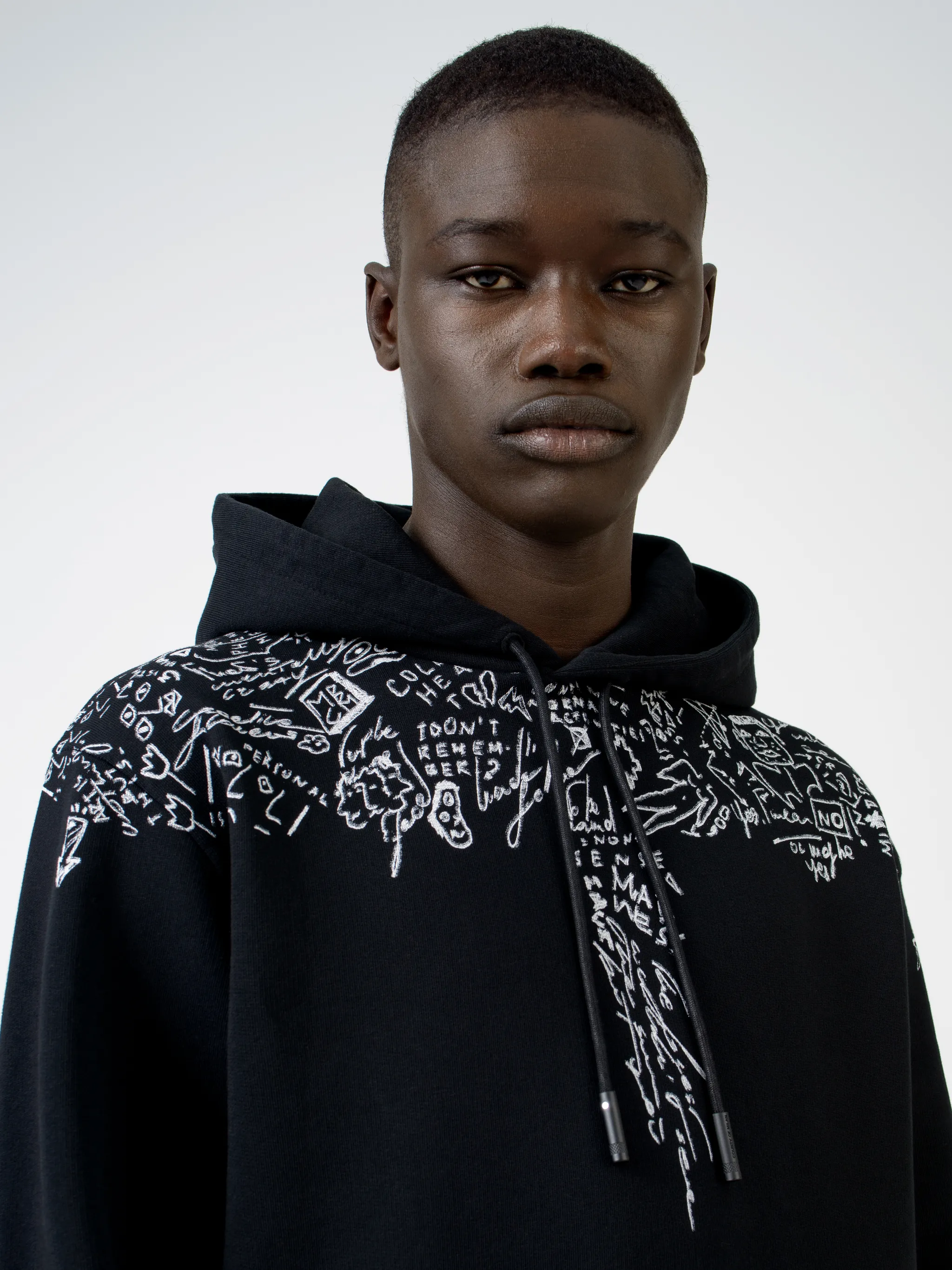 Level up on your casualwear with this black cotton hoodie from Marcelo Burlon County of Milan, printed with doodle logo prints across the chest and shoulders. Get the sketchpad out. Featuring a drawstring hood, a graphic print, long sleeves and a kangaroo pocket.