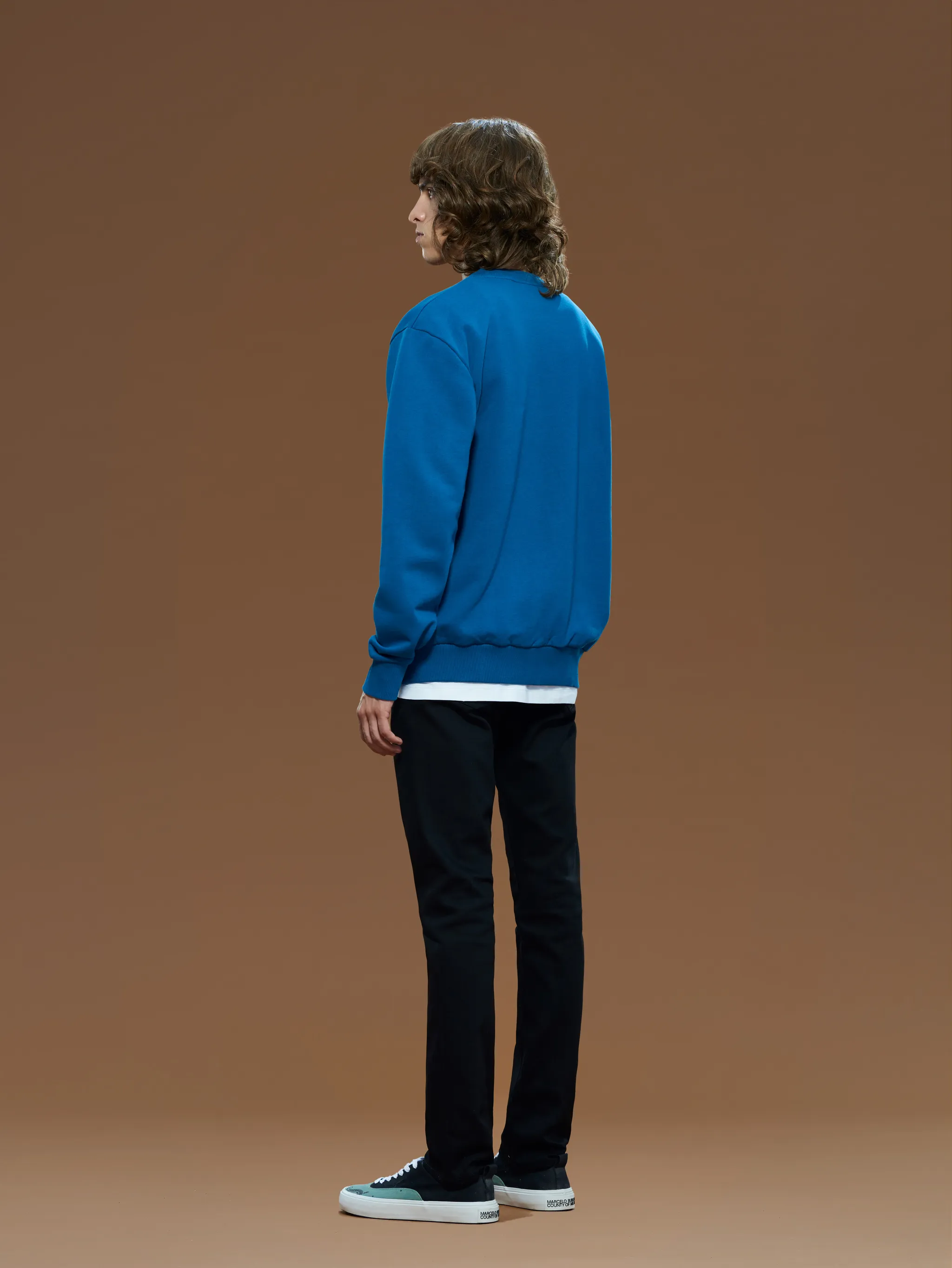 Petrol blue organic cotton Tempera Cross print sweatshirt from Marcelo Burlon County of Milan featuring crew neck, long sleeves, ribbed cuffs, ribbed hem and signature Cross motif. POSITIVELY CONSCIOUS: This Planet Conscious product is made from at least 50% organic materials, which helps you support organic farming practices such as the restricted use of synthetic chemicals and genetically modified seeds, improved soil fertility and better livestock management..