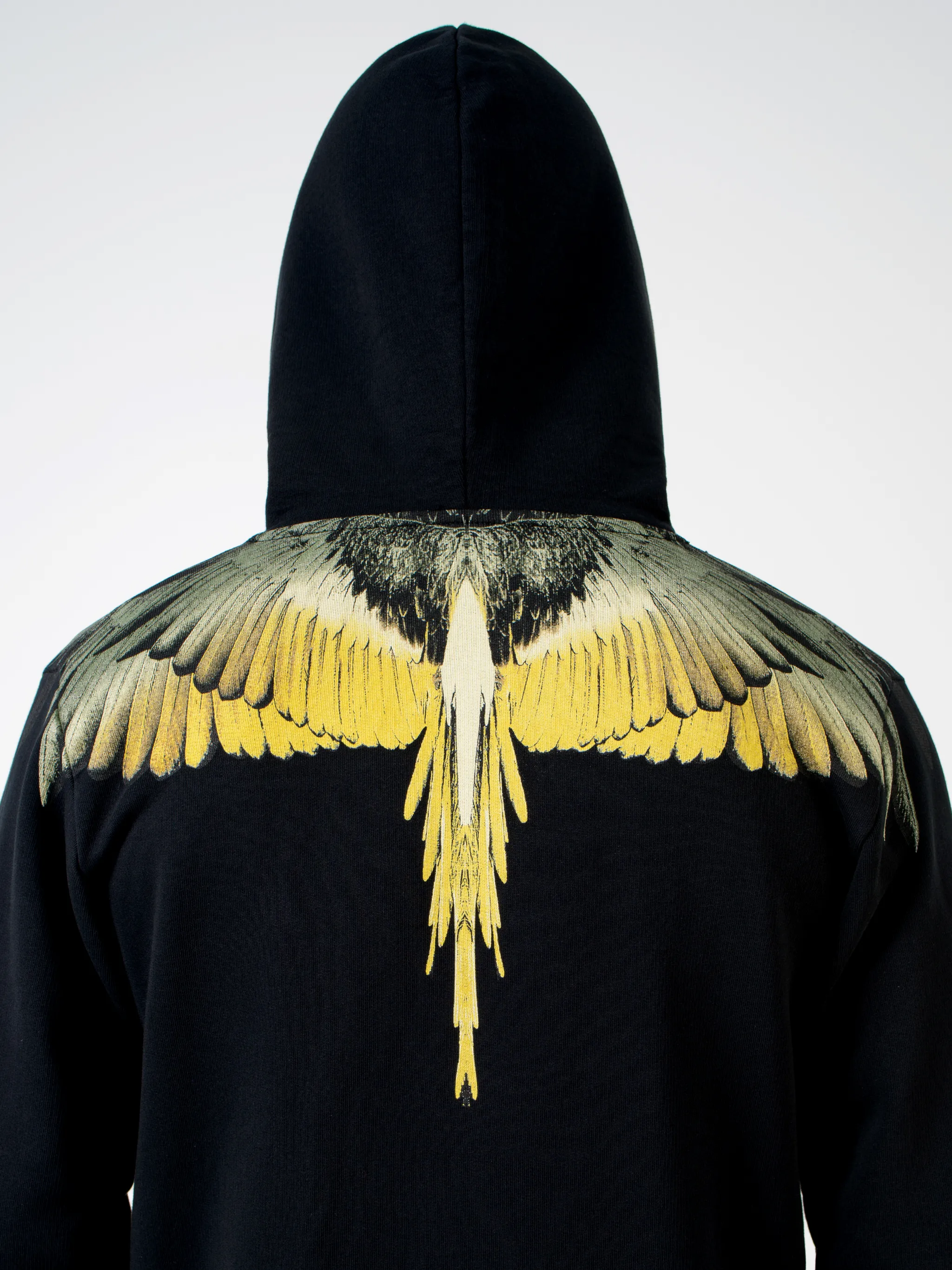 Black/yellow cotton Wings print hoodie from Marcelo Burlon County of Milan featuring drawstring hood, two side pouch pockets, long sleeves, front zip fastening and signature Wings print.
